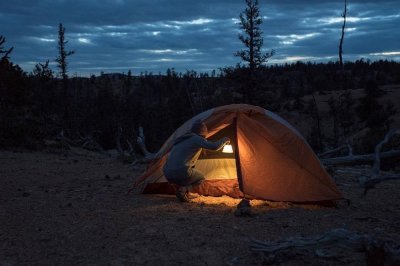 Hang it in the tent via the handle.