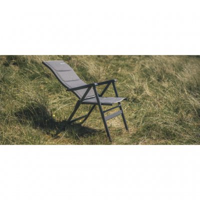 Leun achterover in de campingstoel en lees een boek buiten de caravan of tent.