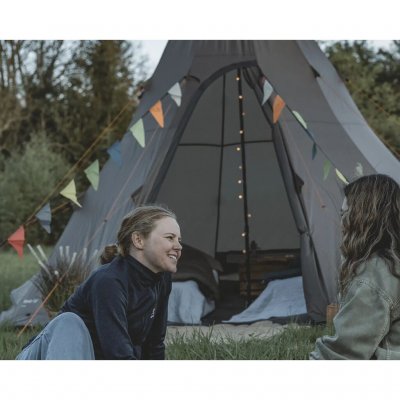 De kleurrijke vlaggen zorgen voor een vrolijke en feestelijke sfeer in de tent.